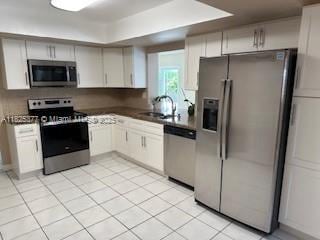 9200 SW 54th St, Cooper City, FL 33328 - kitchen with stainless steel appliances, light tile patterned floors, and dark countertops