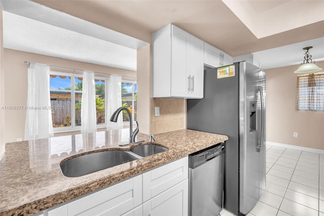 9200 SW 54th St, Cooper City, FL 33328 - kitchen with dishwasher, white cabinetry, light tile patterned flooring, light stone counters, and decorative light fixtures