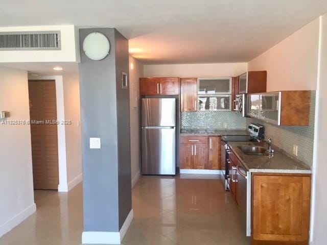 3375 N Country Club Dr Unit 1508, Aventura, FL 33180 - kitchen with stainless steel appliances, tasteful backsplash, brown cabinetry, open shelves, and tile patterned floors
