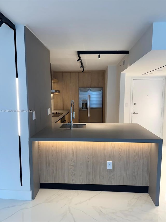 800 N Miami Ave Unit E-901, Miami, FL 33136 - kitchen featuring stainless steel fridge, a peninsula, rail lighting, light marble finish floors, and dark countertops