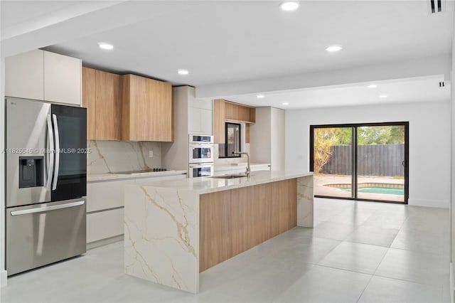 2231 N 49th Ave, Hollywood, FL 33021 - kitchen featuring appliances with stainless steel finishes, modern cabinets, light stone countertops, recessed lighting, and decorative backsplash