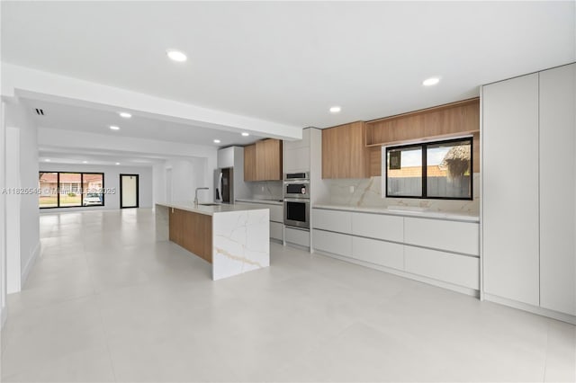 2231 N 49th Ave, Hollywood, FL 33021 - kitchen featuring modern cabinets, stainless steel appliances, recessed lighting, brown cabinets, and tasteful backsplash