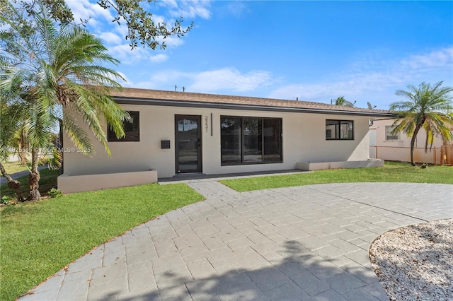 2231 N 49th Ave, Hollywood, FL 33021 - rear view of property featuring stucco siding, a lawn, and a patio