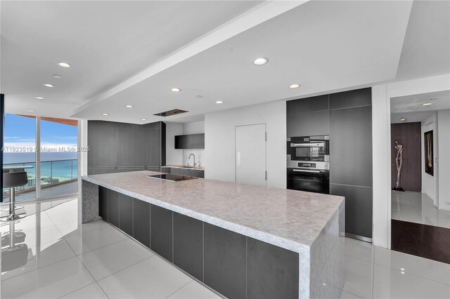 300 S Pointe Dr Unit 3405, Miami Beach, FL 33139 - kitchen featuring modern cabinets, recessed lighting, expansive windows, light countertops, and light tile patterned flooring