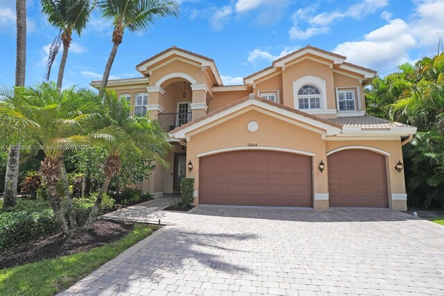 11844 Foxbriar Lake Trl, Boynton Beach, FL 33473 - mediterranean / spanish home with decorative driveway, stucco siding, a tiled roof, and an attached garage