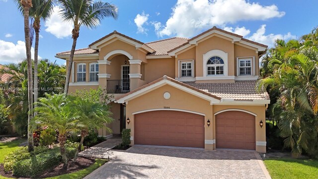 11844 Foxbriar Lake Trl, Boynton Beach, FL 33473 - mediterranean / spanish-style house featuring an attached garage, decorative driveway, a tile roof, and stucco siding
