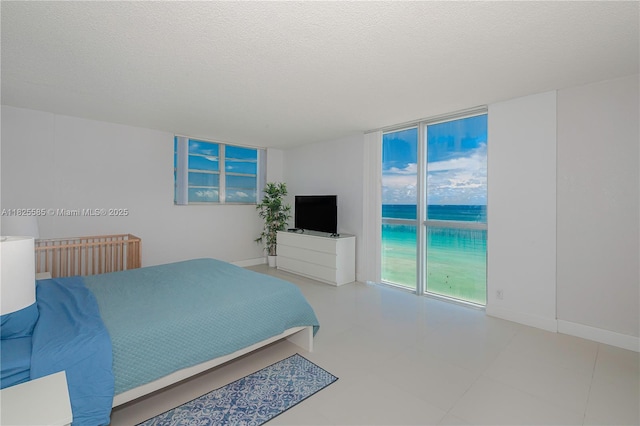 3901 S Ocean Dr Unit 12E, Hollywood, FL 33019 - bedroom featuring a textured ceiling and a wall of windows