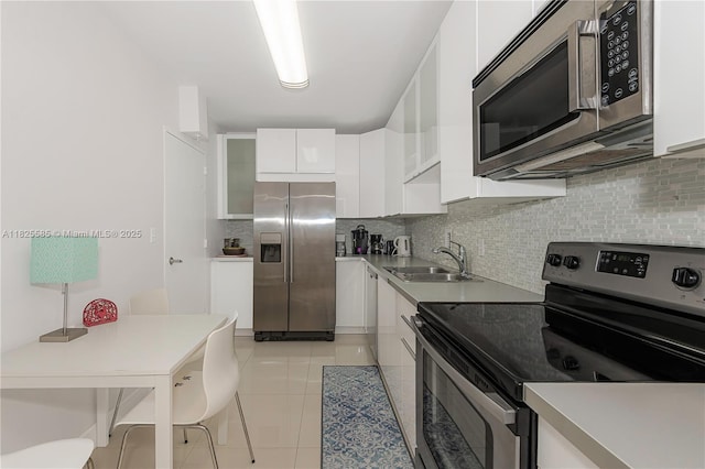 3901 S Ocean Dr Unit 12E, Hollywood, FL 33019 - kitchen with stainless steel appliances, white cabinets, tasteful backsplash, and light tile patterned floors