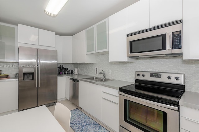 3901 S Ocean Dr Unit 12E, Hollywood, FL 33019 - kitchen featuring stainless steel appliances, tasteful backsplash, white cabinetry, light countertops, and glass insert cabinets