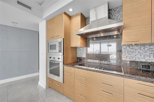 1 N Ocean Blvd Unit 1211, Pompano Beach, FL 33062 - kitchen with appliances with stainless steel finishes, wall chimney range hood, tasteful backsplash, dark stone countertops, and recessed lighting