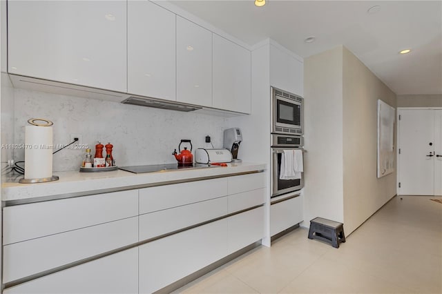 520 Brickell Key Dr Unit A1421, Miami, FL 33131 - kitchen featuring appliances with stainless steel finishes, white cabinets, light countertops, ventilation hood, and recessed lighting