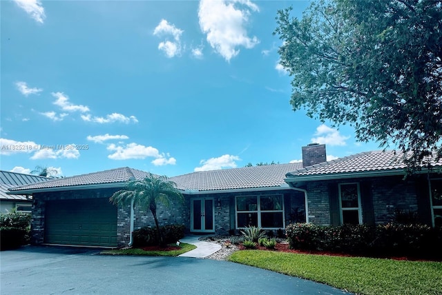 10967 NW 12th Dr, Coral Springs, FL 33071 - ranch-style home with a tiled roof, a chimney, an attached garage, driveway, and french doors