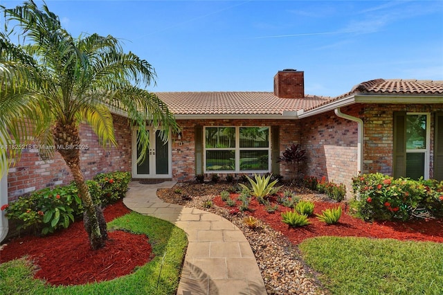 10967 NW 12th Dr, Coral Springs, FL 33071 - entrance to property featuring a tiled roof, a chimney, french doors, and brick siding