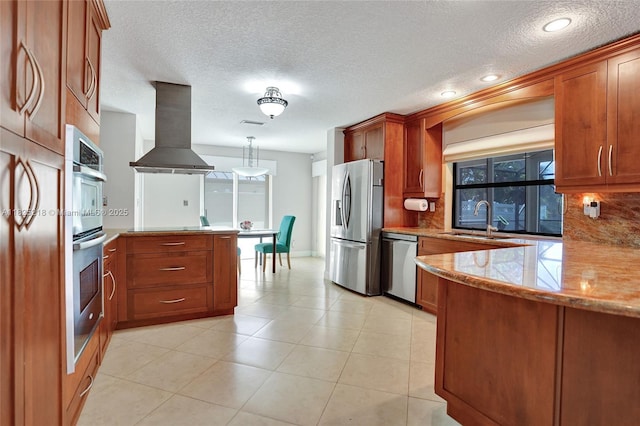 10967 NW 12th Dr, Coral Springs, FL 33071 - kitchen featuring extractor fan, appliances with stainless steel finishes, a peninsula, brown cabinets, and tasteful backsplash