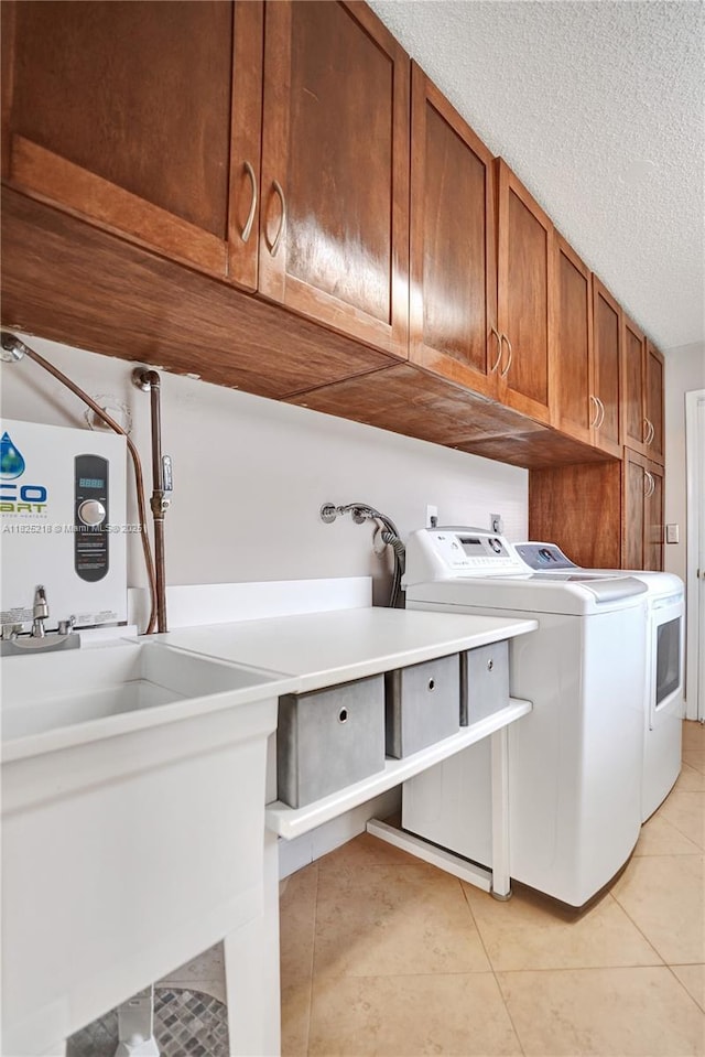 10967 NW 12th Dr, Coral Springs, FL 33071 - laundry room featuring cabinet space, washing machine and dryer, light tile patterned flooring, and a textured ceiling