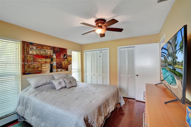 10967 NW 12th Dr, Coral Springs, FL 33071 - bedroom with two closets, dark wood finished floors, a baseboard radiator, a ceiling fan, and a textured ceiling
