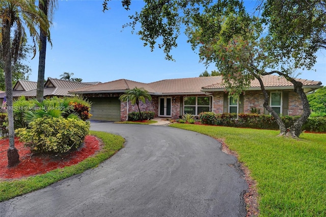 10967 NW 12th Dr, Coral Springs, FL 33071 - single story home featuring a tile roof, a front yard, a garage, asphalt driveway, and brick siding