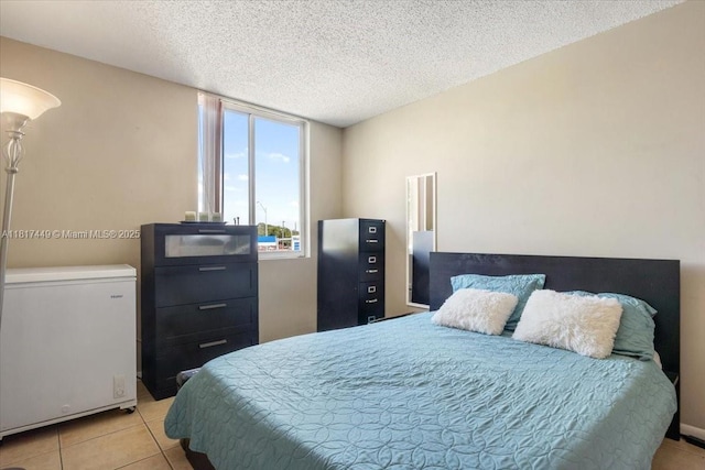 616 NW 26th Ave Unit 210, Miami, FL 33125 - bedroom with fridge, light tile patterned flooring, and a textured ceiling