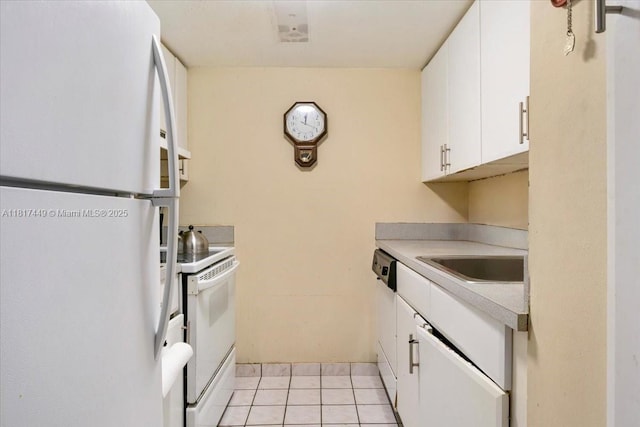 616 NW 26th Ave Unit 210, Miami, FL 33125 - kitchen featuring white appliances, light tile patterned floors, white cabinetry, and light countertops