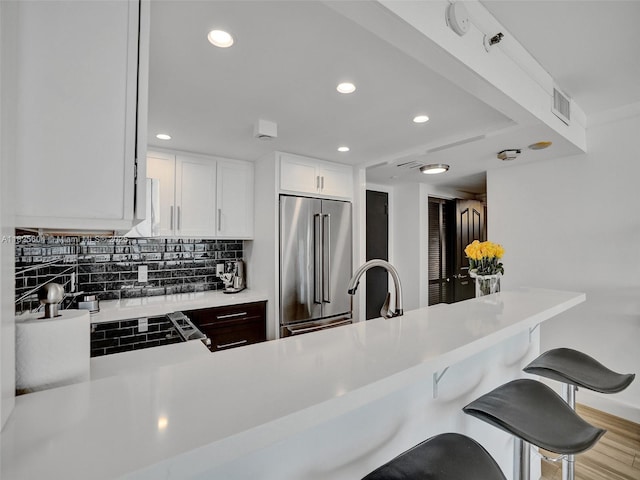 1470 NE 123rd St Unit Aph9, North Miami, FL 33161 - kitchen with high end refrigerator, light countertops, recessed lighting, a kitchen breakfast bar, and decorative backsplash