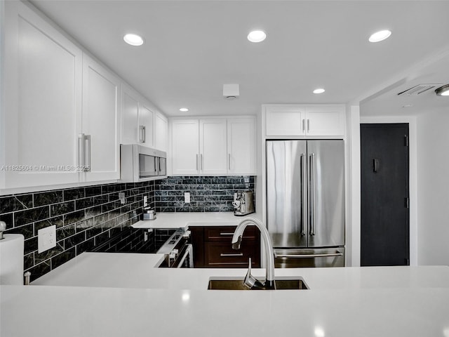 1470 NE 123rd St Unit Aph9, North Miami, FL 33161 - kitchen with stainless steel appliances, recessed lighting, decorative backsplash, white cabinetry, and light countertops