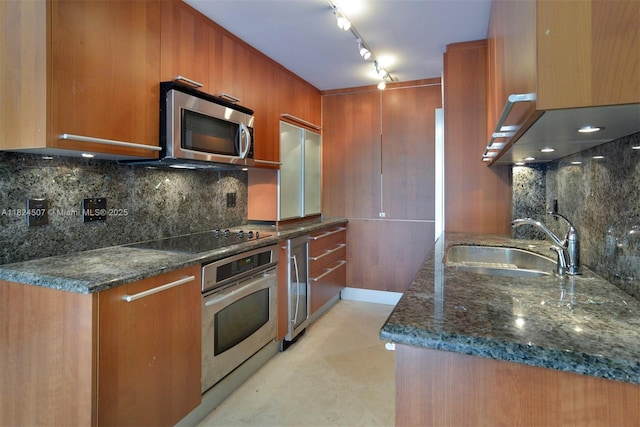 1670 Bay Rd Unit 2D, Miami Beach, FL 33139 - kitchen with appliances with stainless steel finishes, brown cabinets, dark stone countertops, backsplash, and modern cabinets
