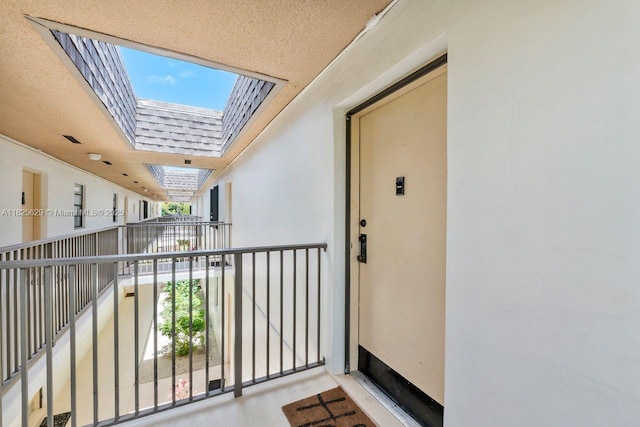 8261 SW 128th St Unit 215, Pinecrest, FL 33156 - view of exterior entry featuring a balcony, stucco siding, and a shingled roof