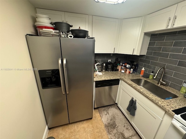 1428 SE 4th Ave Unit 103, Deerfield Beach, FL 33441 - kitchen with appliances with stainless steel finishes, white cabinetry, decorative backsplash, and light stone counters