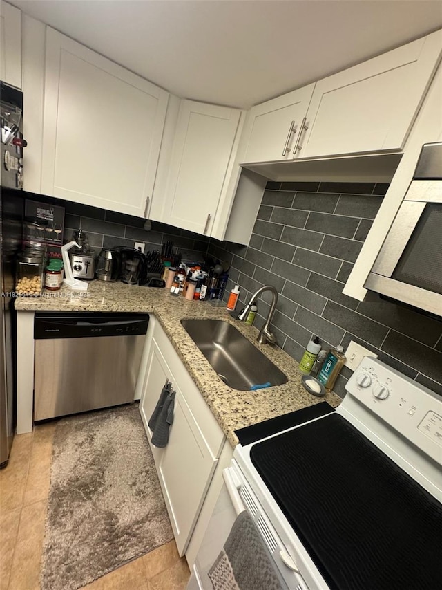 1428 SE 4th Ave Unit 103, Deerfield Beach, FL 33441 - kitchen featuring stainless steel dishwasher, electric stove, decorative backsplash, and white cabinetry