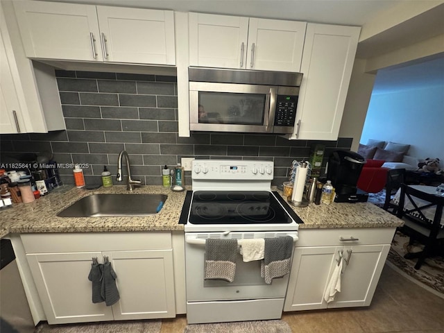 1428 SE 4th Ave Unit 103, Deerfield Beach, FL 33441 - kitchen featuring stainless steel microwave, electric range, backsplash, and white cabinets
