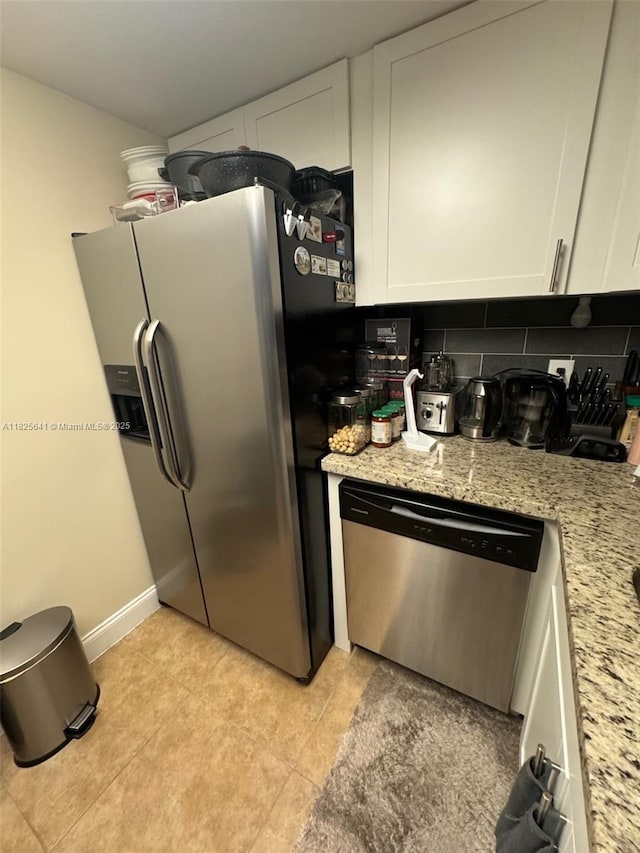 1428 SE 4th Ave Unit 103, Deerfield Beach, FL 33441 - kitchen with appliances with stainless steel finishes, white cabinets, light tile patterned flooring, decorative backsplash, and light stone counters