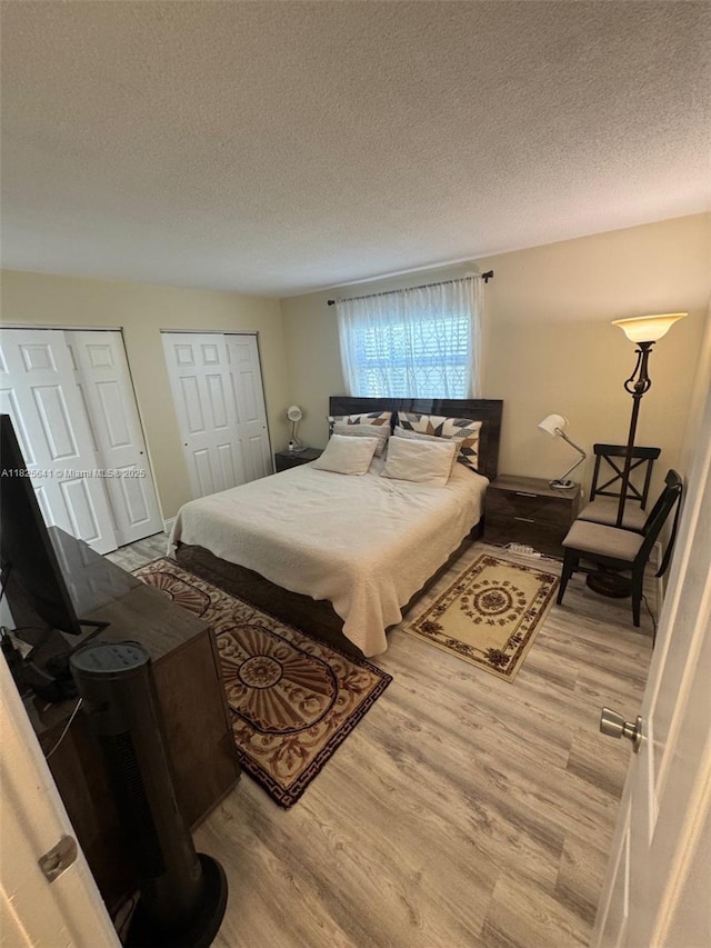 1428 SE 4th Ave Unit 103, Deerfield Beach, FL 33441 - bedroom with wood finished floors, a textured ceiling, and two closets