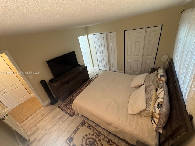 1428 SE 4th Ave Unit 103, Deerfield Beach, FL 33441 - bedroom featuring multiple closets, wood finished floors, and a textured ceiling