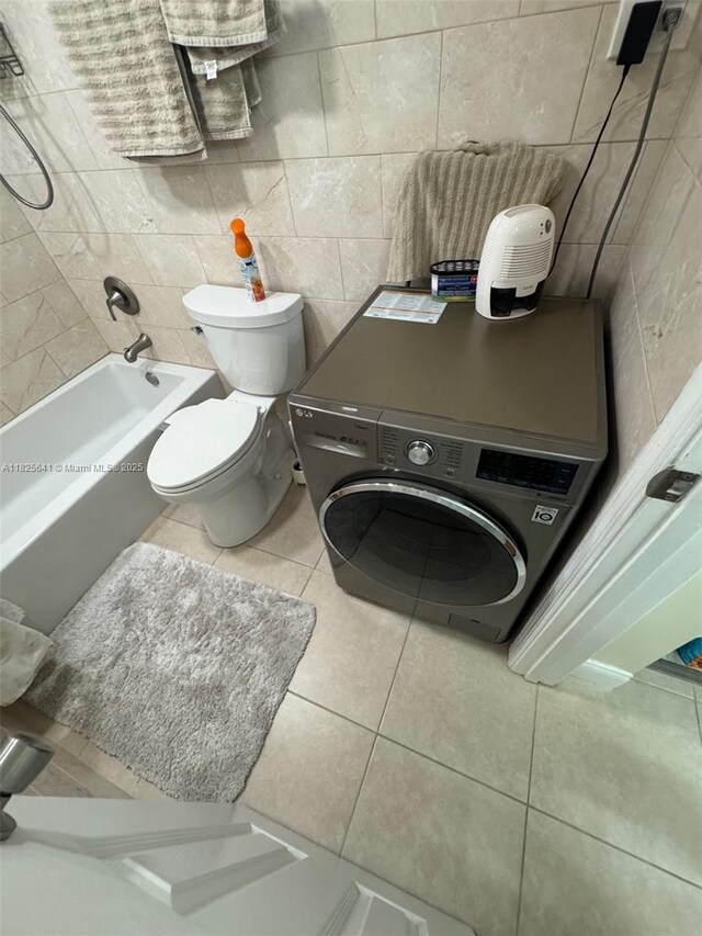 1428 SE 4th Ave Unit 103, Deerfield Beach, FL 33441 - full bath with tile patterned floors, tile walls, and washer / clothes dryer
