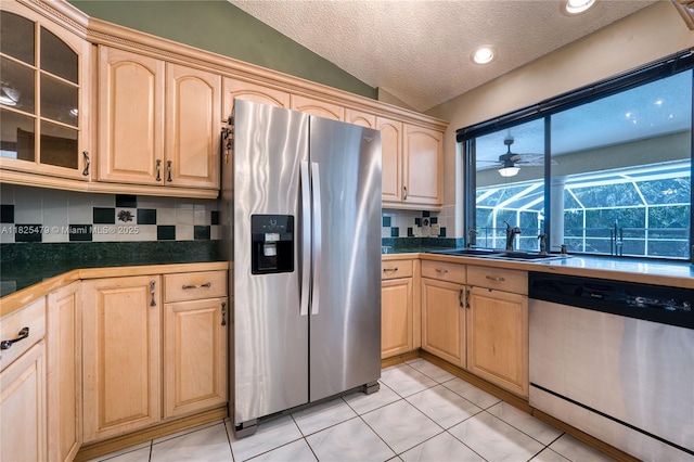 1381 SW Leisure Ln, Port St Lucie, FL 34953 - kitchen with stainless steel appliances, light brown cabinetry, decorative backsplash, glass insert cabinets, and a textured ceiling