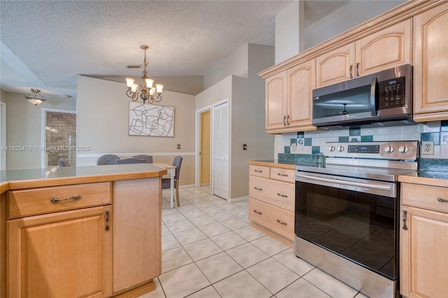 1381 SW Leisure Ln, Port St Lucie, FL 34953 - kitchen featuring stainless steel appliances, light brown cabinetry, a chandelier, decorative backsplash, and a textured ceiling