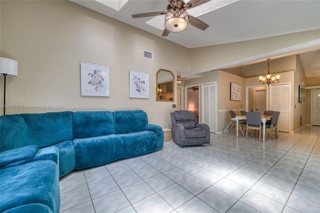 1381 SW Leisure Ln, Port St Lucie, FL 34953 - living room featuring vaulted ceiling, a chandelier, a ceiling fan, and light tile patterned floors