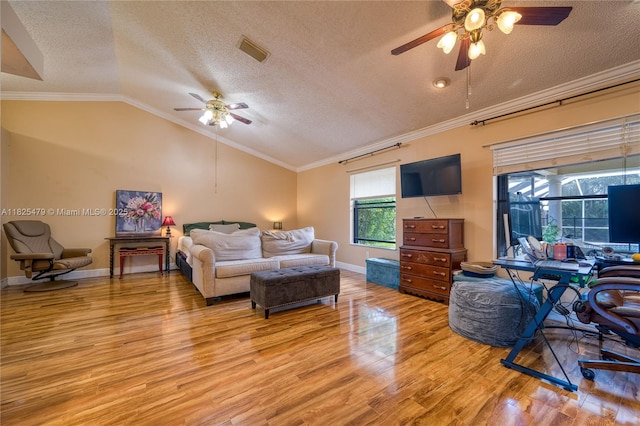 1381 SW Leisure Ln, Port St Lucie, FL 34953 - living area featuring a ceiling fan, light wood-type flooring, a textured ceiling, lofted ceiling, and ornamental molding