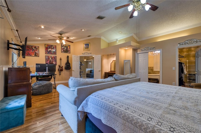1381 SW Leisure Ln, Port St Lucie, FL 34953 - bedroom featuring a textured ceiling, wood finished floors, vaulted ceiling, crown molding, and a walk in closet