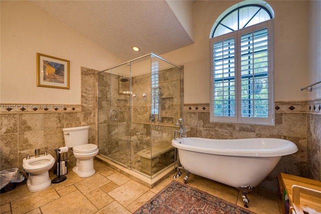 1381 SW Leisure Ln, Port St Lucie, FL 34953 - full bath featuring tile walls, a freestanding bath, wainscoting, a shower stall, and a bidet