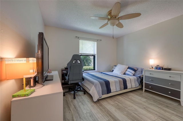 1381 SW Leisure Ln, Port St Lucie, FL 34953 - bedroom featuring a textured ceiling, light wood-style floors, an office area, and ceiling fan
