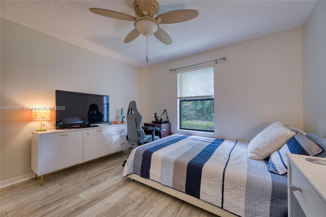 1381 SW Leisure Ln, Port St Lucie, FL 34953 - bedroom with light wood-type flooring, a textured ceiling, and a ceiling fan
