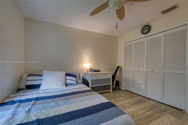 1381 SW Leisure Ln, Port St Lucie, FL 34953 - bedroom with light wood-style floors, a closet, ceiling fan, and a textured ceiling