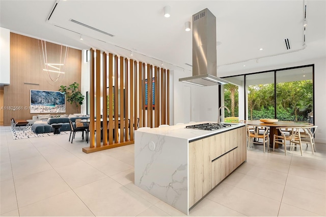 7660 SW 124th St, Pinecrest, FL 33156 - kitchen featuring modern cabinets, island exhaust hood, a large island, light stone countertops, and light tile patterned floors