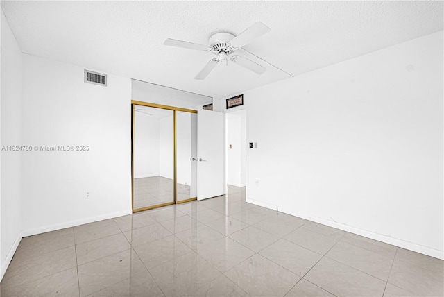 3551 NE 169th St Unit 312, North Miami Beach, FL 33160 - unfurnished bedroom featuring a textured ceiling, a closet, ceiling fan, and tile patterned flooring