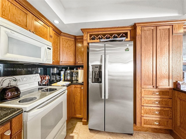 6767 Collins Ave Unit 704, Miami Beach, FL 33141 - kitchen featuring white appliances, brown cabinets, and dark countertops