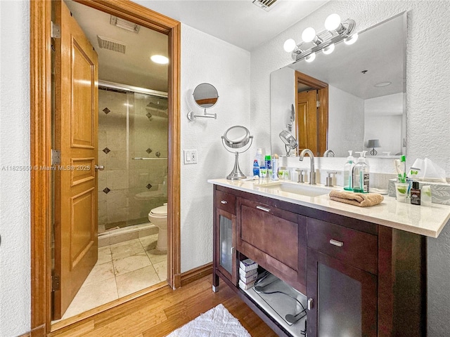 6767 Collins Ave Unit 704, Miami Beach, FL 33141 - full bathroom featuring a textured wall, a shower stall, vanity, and wood finished floors