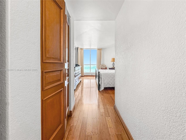 6767 Collins Ave Unit 704, Miami Beach, FL 33141 - hall featuring a textured wall and light wood-style floors