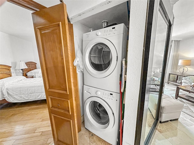 6767 Collins Ave Unit 704, Miami Beach, FL 33141 - laundry room with stacked washing machine and dryer and light wood-style flooring
