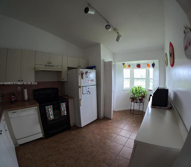 985 NE 34th Ave Unit 203, Homestead, FL 33033 - kitchen featuring white appliances, under cabinet range hood, dark tile patterned flooring, vaulted ceiling, and track lighting